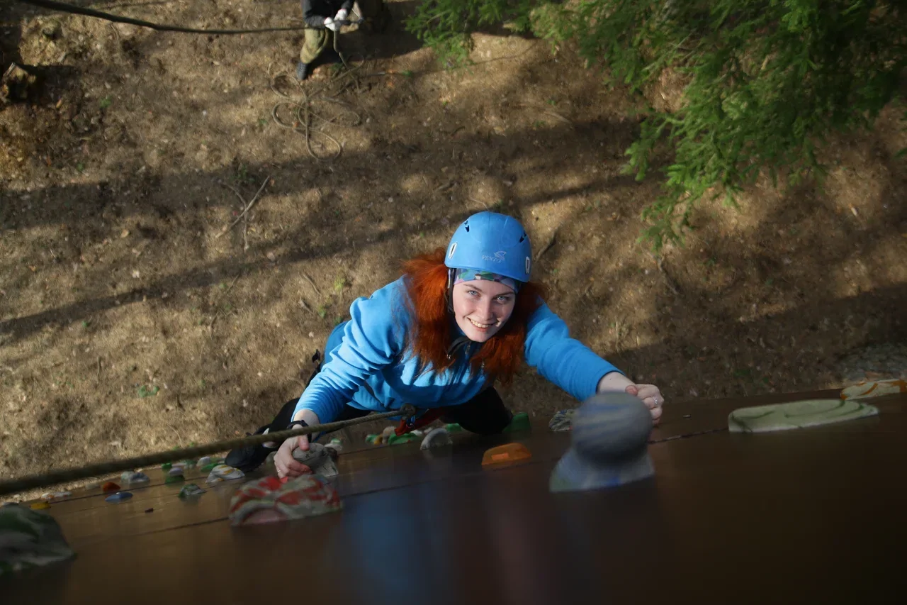 Взрослый участник преодолевает трассу скалодрома в Минске