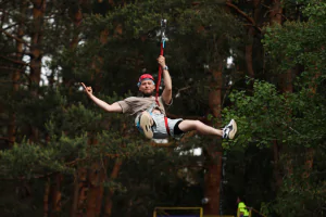 Посетитель парка наслаждается катанием на тарзанке с видом на природу