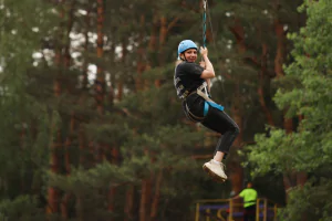 Семейный отдых на троллее — ребёнок спускается с высоты под присмотром