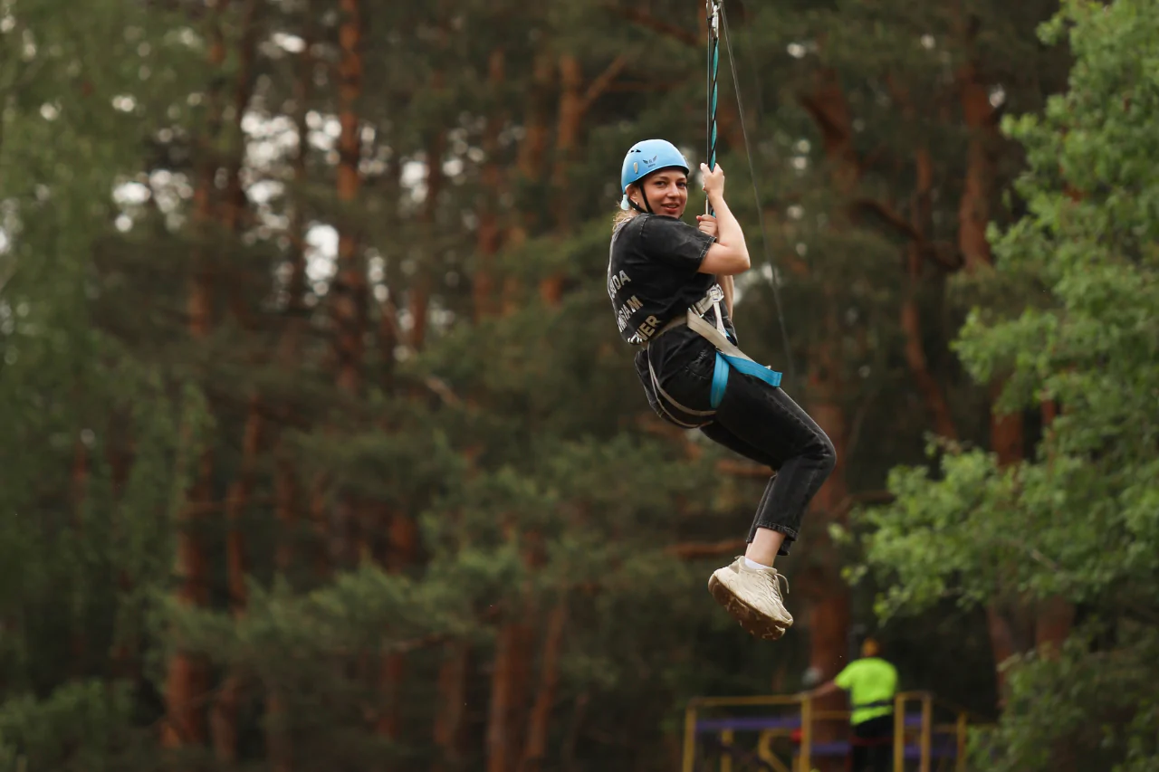 Семейный отдых на троллее — ребёнок спускается с высоты под присмотром